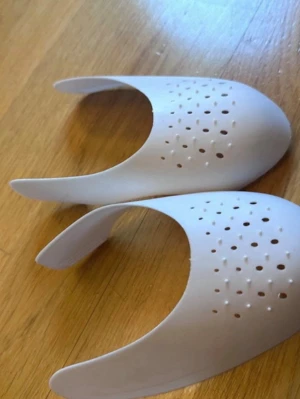 Crease skydd - Säljer ett par vita skoinlägg i plast som fungerar som tåskydd eller formhållare för sneakers. De har perforerade hål för ventilation och hjälper till att behålla formen på skorna. Perfekt för dig som vill undvika veck på dina favoritsneakers.