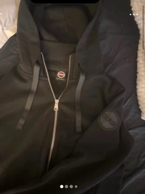 Svart zip up hoodie från Colmar - Säljer en svart hoodie från Colmar med dragkedja framtill och snören i luvan. Märket är glittrigt. Storlek S, pris kan diskuteras 💞 passar xs-m