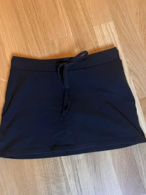 Minikjol med inbyggda shorts - En svart minikjol med inbyggda shorts från Gina tricot Young 14+ i storlek xxs.