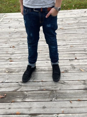 Nudie jeans slim fit med slitningar - Säljer ett par mörkblå slim fit jeans med snygga slitningar och kontrastsömmar. Jeansen har fem fickor, uppvikta benslut och klassisk knappgylf. Perfekta för dig som gillar en archive eller grisch stil. Priset går att diskutera vid snabb affär! Storleks lappen sitter inte kvar men de är storlek W27 och L32. Var inte rädd att fråga😁
