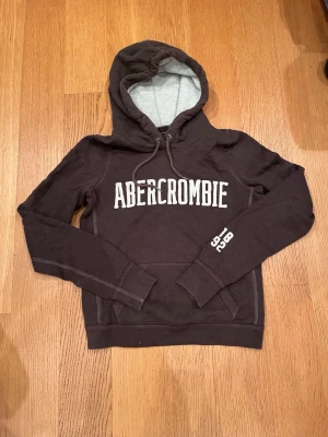 Hoodie från Abercrombie - Mörkbrun vintage hoodie från Abercrombie med vit logga på bröstet och siffrorna 1892 på ärmen. Strl M dam, men storlek Xs-S man. Priset är diskuterbart vid snabb affär!