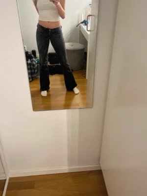 Svarta bootcut jeans från weekday - Säljer ett par svarta bootcut jeans från week day med låg midja och klassisk femficksmodell. Jeansen har en snygg tvättad look och är tillverkade i ett stretchigt denimtyg som sitter skönt. Perfekta för dig som gillar en trendig och avslappnad stil. Står ingen storlek men passar någon som är xs/s 32-34