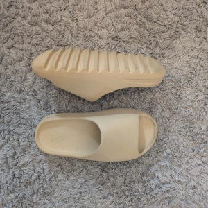 Adidas Yeezy Slide i beige - Säljer ett par Adidas Yeezy Slide i beige färg. Dom är replicas! Använts med omsorg. 