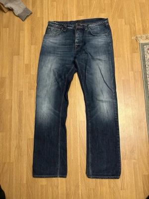 Nudie Jeans - Easy Emil - Sällsynt modell - Säljer dessa jeans ifrån Nudie jeans i modellen Easy Emil. Sällsynt modell som sitter nice över skorna. Midja: 43cm. Innerbenslängd: 85cm.