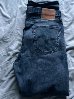 Levi's 501  jeans -  blå gråa 501  jeans från Levi's med rak passform. Jeansen har knappgylf och tydlig läderpatch bak med diskreta slitningar för en tidlös look. W33 L32