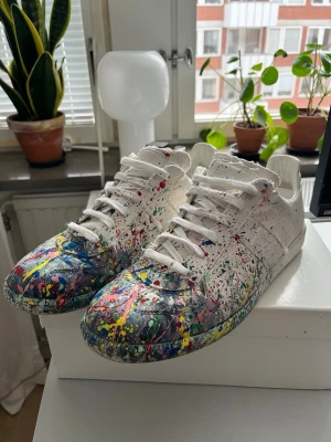 Maison Margiela Gats Custom - Äkta margiela gats som varit custom paintade i andra hand av förra ägaren vilket ger de en väldigt snygg och unik look, strlk 45. De är klart äkta och dust bags + box följer med. Originellt är dessa endast blå splatter, väldigt bra skick