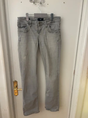 Ljusgrå botcut jeans från LTB - Säljer ett par ljusgrå jeans från LTB med botcut och klassisk femficksmodell. Jeansen har en diskret tvättad look och är tillverkade i ett mjukt denimtyg som sitter skönt. Perfekta för dig som gillar en clean och enkel stil.