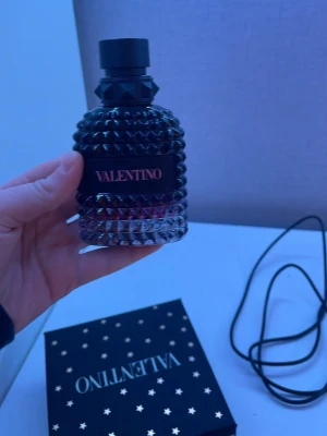 Valentino parfym med nitar - Säljer en lyxig parfym från Valentino i en cool, svart glasflaska med nitar och elegant design. Flaskan har ett mönstrat yttre och svart etikett med Valentino-loggan. Kommer med en snygg svart ask dekorerad med guldstjärnor. Ni kan få med den andra delen också men det är 100+. 90% kvar av parfymen typ
