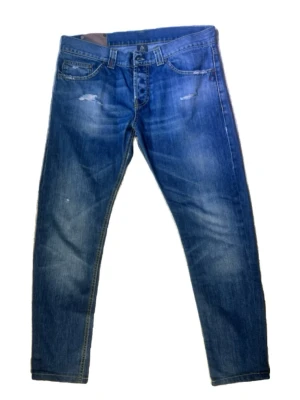 Dondup jeans slim blåa - Säljer ett par blå dondups med slim fit och lätt slitna detaljer vid fickorna och knäna. Jeansen har klassisk femficksdesign och är gjorda i denim. Strl 34