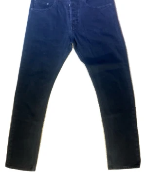 Svarta dondup jeans 32 - Snygga  svarta dondup jeans med slim passform och klassisk femficksdesign. Jeansen har normal midja och stängs med dragkedja och knapp.  Strl 32 i slim