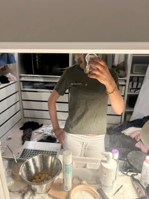 Olivgrön t-shirt från Calvin Klein - Säljer en olivgrön t-shirt från Calvin Klein med diskret logga på bröstet. T-shirten har klassisk passform, rund halsringning och korta ärmar. Perfekt basplagg i mjuk bomull som funkar till allt.