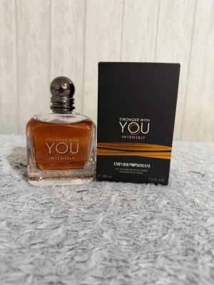 Emporio Armani Stronger With You Intensely - Emporio Armani Stronger With You Intensely är en parfym för honom med en elegant glasflaska och mörkbrun doftvätska. Flaskan har en rundad silverfärgad kork och kommer i en stilren svart kartong med guldiga detaljer. Volymen är 100 ml.