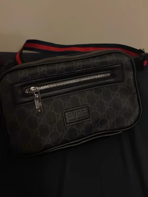 Svart axelväska från Gucci - Snygg svart axelväska från Gucci med klassiskt GG-mönster 