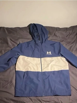 Under armour jacka - Jackan är jätte fin och sportig. Jackan har ett par hål i framsidan och kedjan finns inte för den gick sönder, vilket betyder att man inte kan stänga jackan. Annars e den fin och är väldigt skön att ha på sig. Och funkar att återanvända den