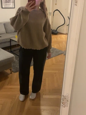 Oversized beige stickad tröja - Mysig oversized stickad tröja i beige med rund halsringning och breda ärmar. Tröjan har en avslappnad passform och ribbstickade muddar vid ärmslut och nederkant. Perfekt för lager på lager och chill vardagsstil.