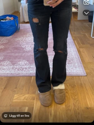 Svarta bootcut jeans med slitningar - Snygga svarta bootcut jeans med slitningar på knäna. Perfekta för en trendig look. De har en låg midja och klassisk femficksdesign. (Har gjort hålen själv)