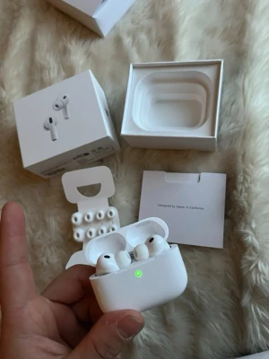 Apple AirPods Pro trådlösa hörlurar - Säljer ett par vita Apple AirPods Pro med laddningsetui och extra silikonpluggar. Hörlurarna är kompakta, har en stilren design och levereras i originalförpackning. Perfekta för dig som vill ha trådlös frihet och grymt ljud till mobilen eller datorn.