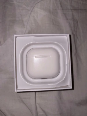 Apple AirPods 4  - Säljer ett par Apple AirPods 4 i vitt med trådlöst laddningsetui. Snygg och kompakt design i plast, perfekt för dig som vill ha smidiga och stilrena in-ear hörlurar. Levereras i originalförpackning.
