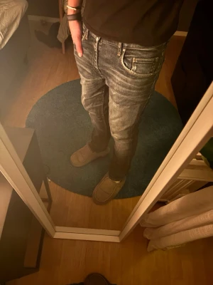 Mörkblå raka jeans från tiger of sweden - Säljer ett par mörkblå jeans från TOS med klassisk femficksdesign och raka ben. Jeansen har subtila slitningar och kontrastsömmar, samt en läderpatch bak i midjan. Perfekta till vardags och passar till det mesta. Materialet är slitstarkt jeans. Storleken är 32/32