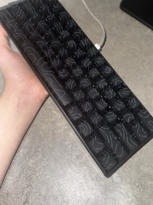 Svart mekaniskt Keyboared (Shaft/Key remiver kmr med!) - Säljer ett kompakt svart mekaniskt tangentbord med unika vita linjemönster på keycapsen. Tangenterna har blå switchar som ger ett klickigt ljud. Perfekt för gaming eller skrivande. USB-anslutning. Snygg och modern design som sticker ut på skrivbordet.