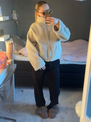Beige teddyjacka med dragkedja - Mysig beige teddyjacka med hög krage och dragkedja framtill. Jackan har en avslappnad passform och är tillverkad i fluffigt teddy-material som håller dig varm. Perfekt för kyliga dagar och enkel att matcha med olika outfits. Från lager 157!