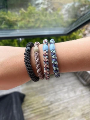 Färgglatt flätat armband med pärla - Knekki i 4-pack med blå,beige och svarta toner kanska neutrala och orginalpris är 120kr för ett 4 pack