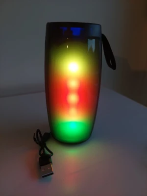 Trådlös högtalare med LED-ljus - Snygg trådlös högtalare i cylinderformad design med färgglada LED-ljus som skiftar mellan olika färger. Högtalaren har ett svart plasthölje och medföljande USB-laddkabel. Perfekt för att skapa stämning med både musik och ljusshow.