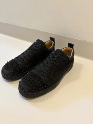 Svarta Christian Louboutin skor 44 - Svart Christian Louboutin mocka skor med nitar. Storlek 44, skorna är i bra skick det är endast nitar som saknas på båda skor men inget som syns vid användning. Skriv vid minsta fråga eller fundering🤝