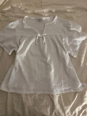 Vit blus med rosett och puffärm - Söt vit blus med en rosett och puffigaärmar. Ett tunt och uppfriskande material inför sommaren 🫶🏼