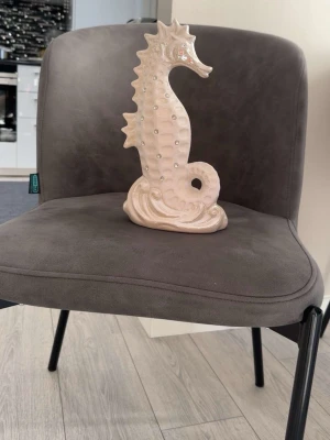 Dekorativ sjöhäst i keramik - Säljer en ljusbeige dekorativ sjöhäst i keramik. Figuren har en glansig yta och små upphöjda detaljer längs kroppen. Perfekt som inredningsdetalj för att ge rummet en unik touch.