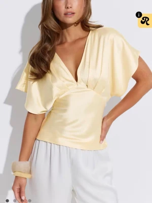 Topp i satin - Snygg topp i satin med. Elegant topp som är figursydd i midjan, finns två band man knyter i ryggen. Aldrig använd, prislapp kvar💞helt slutsåld 