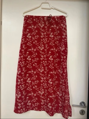 Röd långkjol  - Röd mönstrad långkjol med slits i storlek XS/S, mycket fint skick!🌸