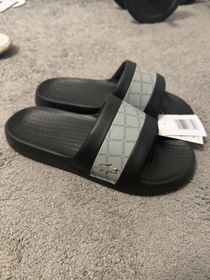 Lacoste tofflor - Helt oanvänd lacoste slides skick 10/10