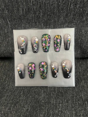 Press-on naglar || Storlek L - Snygga press-on naglar i svart och grått med cool ombre-effekt. Dekorerade med färgglada glitterprickar och rhinestones för extra bling. Naglarna har en rak, något avsmalnande form och är perfekta för dig som vill sticka ut. Storlek L, Det du får med dig : * Fil och manikyr pinne * nagellim klistermärken * 2 lappar av rengöring för naglar.