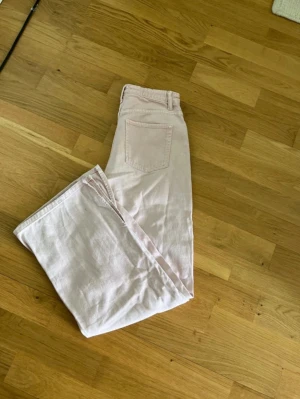 Ljusrosa raka jeans med slits - Säljer ett par ljusrosa jeans med raka ben och slits nertill. Jeansen har klassisk femficksdesign och hög midja. Perfekta för dig som gillar en avslappnad och trendig stil. De har en justerbar midja. Storleken är 158 men man kan inte sätta en barnstorlek så den storlek jag skriver stämmer INTE