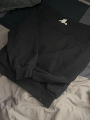 Svart offshoulder tjocktröja  - Off shoulder svart tröja.