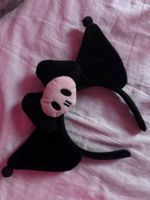 Kuromi diadem  - Sött svart kuromi diadem. Perfekt accessoar för dig som gillar kawaii-stil eller vill sticka ut lite extra. Tillverkad i mjukt plyschmaterial som sitter bekvämt på huvudet.