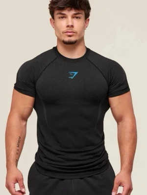 Svart träningströja från Gymshark - Snygg svart Onyx träningströja från Gymshark med korta ärmar och rund hals. Tröjan har en tight passform och är tillverkad i ett stretchigt funktionsmaterial som andas. Gymshark-logga i blått på bröstet. Perfekt för gymmet eller löpning.
