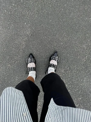 GANNI Buckle Ballerinaskor - BLACK FEMININE BUCKLE BALLERINASKOR  Inköpta förra året - sparsamt använda och inte använda senaste 6mån. Normalt slitage, skick enligt bilder. Annars inget att anmärka på.