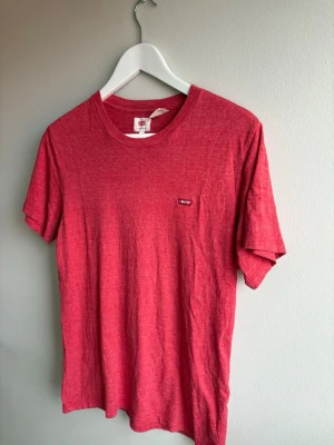 Röd t-shirt från Levi's Small - Röd t-shirt från Levi's med klassisk rund hals och liten Levi's-logga på bröstet. Storlek small. T-shirten är enkel och stilren, perfekt till jeans eller shorts. Tillverkad i mjuk bomull och har korta ärmar för en avslappnad look.