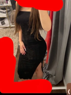 Svart långklänning med slits - Snygg svart långklänning i figurnära modell med slits på sidan. Klänningen är ärmlös och har en enkel, stilren design som framhäver siluetten. Perfekt för dig som vill ha en klassisk och elegant look.