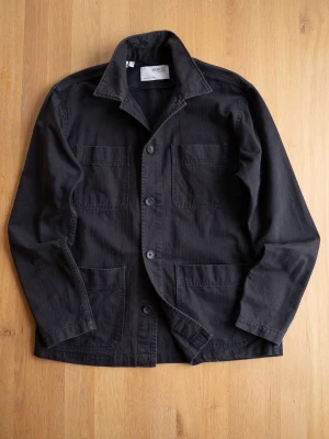 Svart overshirt från Selected Homme - Stilren svart overshirt från Selected Homme med fyra stora fickor framtill och klassisk krage. Tillverkad i ett kraftigare bomullstyg och stängs med knappar. Perfekt lager-på-lager-plagg för en avslappnad look.