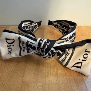 Diadem - Svart/vitt diadem med lite beige i. Justerbar rosett, då det är någon slags metall i. Man ska även kunna ta bort den. Har dock aldrig testat, då jag aldrig använt det. Ca 6 cm där det är som bredast.