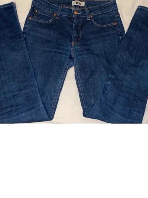 Acne jeans - Säljer ett par blå jeans från Acne med utsvängda ben och klassisk femficksmodell. Jeansen har en snygg mörk tvätt och detaljer i kontrastsömmar.