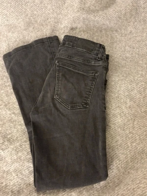 ”Stonewashed” jeans  - Säljer ett par svarta jeans från 157 i storlek XXS Short. Klassisk femficksmodell med utsvängda ben och låg midja (20 cm). Jeansen har en snygg tvättad svart färg och är perfekta till vardagslooken. Materialet är mjukt och stretchigt för extra komfort. OBS uppsydda och innerbenslängd 67 cm. Perfekta att göra till shorts om det önskas.