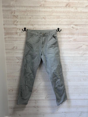 Grå jeans från Carhartt - Säljer min brors gråa jeans från Carharrt, knappr använda och har inga märken eller skavanker. Nypris ligger på runt 2000, säljer för de inte längre passar. Passar honom som är 187. 