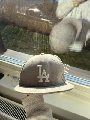 Grå LA Dodgers keps - Snygg grå LA Dodgers keps. En trendig keps med fina gråvita färger och design! Materialet är skönt och kepsen har även lufthål. Mycket bra skick!