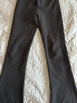Svarta utsvängda kostymbyxor  - Säljer ett par svarta kostymbyxor med utsvängda ben o fickor där bak 
