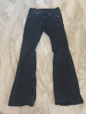 Svarta låg midjade  bootcut jeans från Hm - Säljer ett par svarta låg midjade bootcut jeans från HM. Perfekta för dig som vill ha ett par bekväma jeans i stretchigt material.