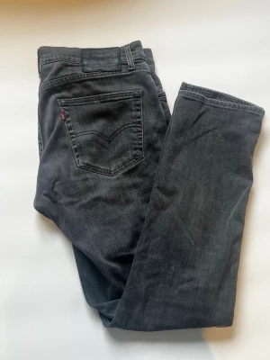 Levi's 511 jeans - Säljer ett par svarta Levi's 511 jeans med klassisk femficksdesign och rak passform. Perfekta för dig som gillar en clean stil.